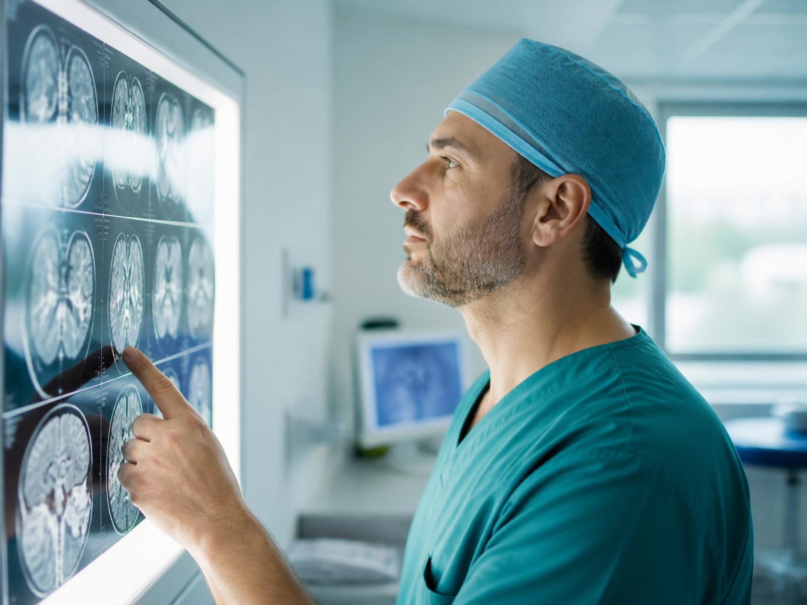 A specialist surgeon reviewing MRI scans on a lightbox